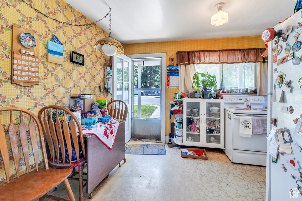 Kitchen with white appliances and wallpapered walls