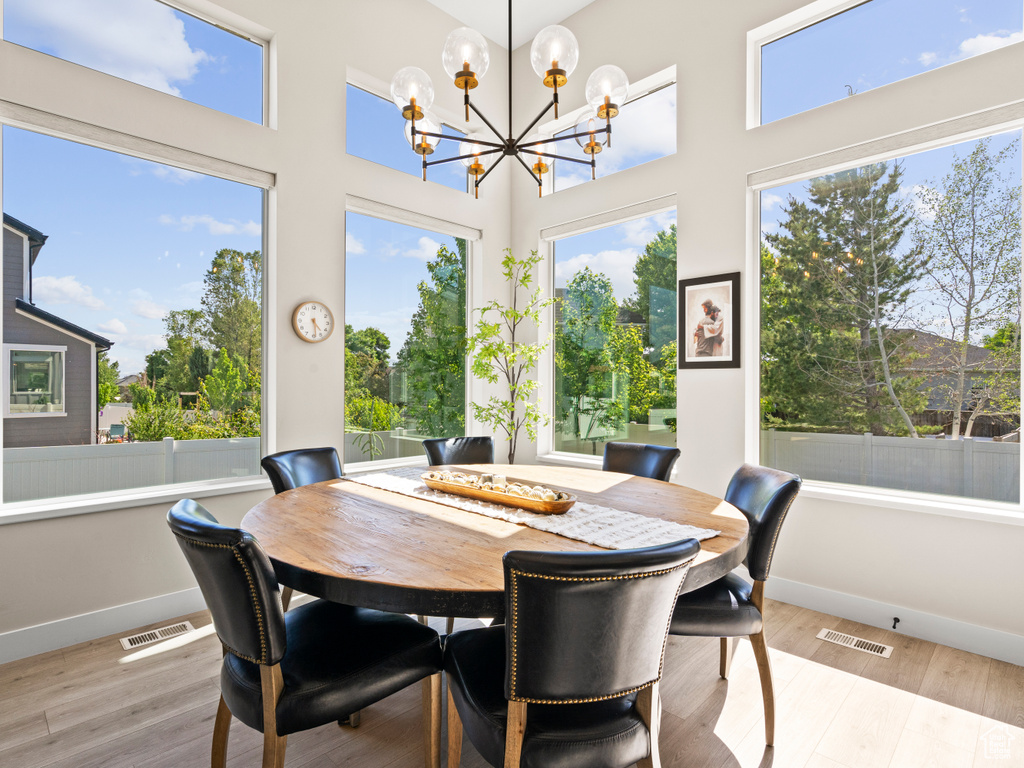 Dining room featuring a chandelier, baseboards, wood finished floors, and a high ceiling