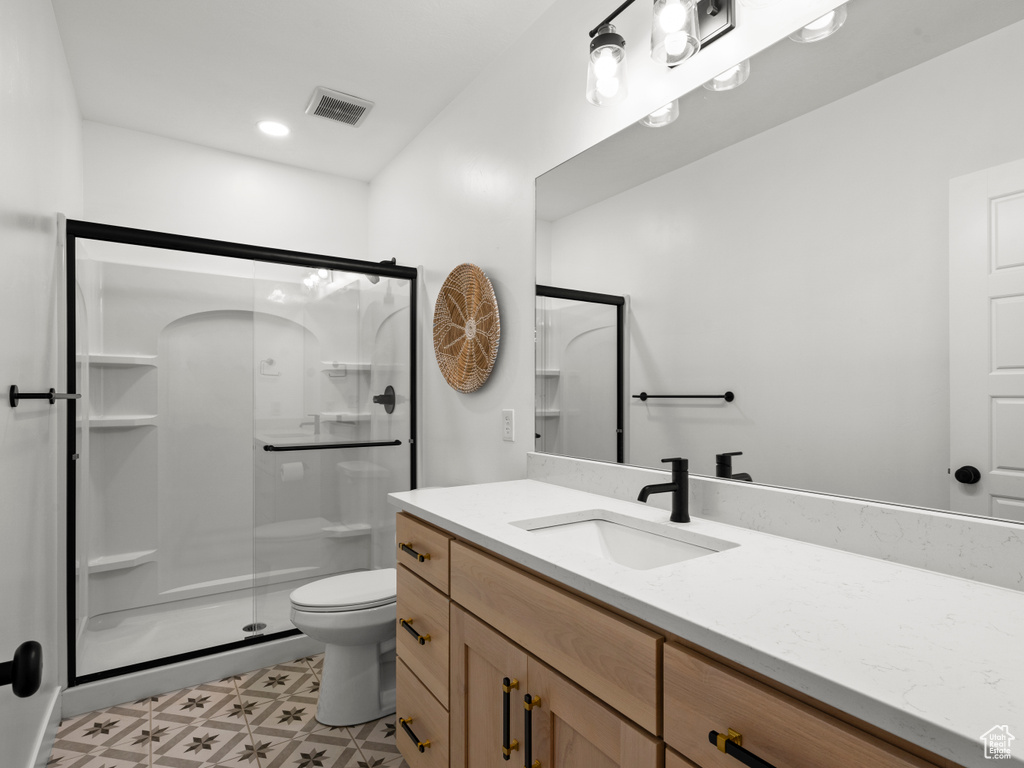 Full bathroom featuring vanity, a stall shower, toilet, tile patterned floors, and recessed lighting