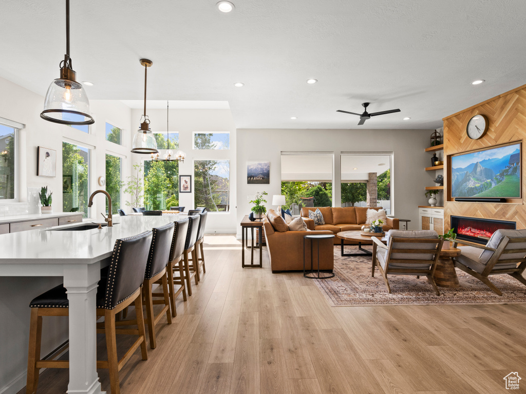 Living area featuring recessed lighting, a tile fireplace, light wood-type flooring, and ceiling fan