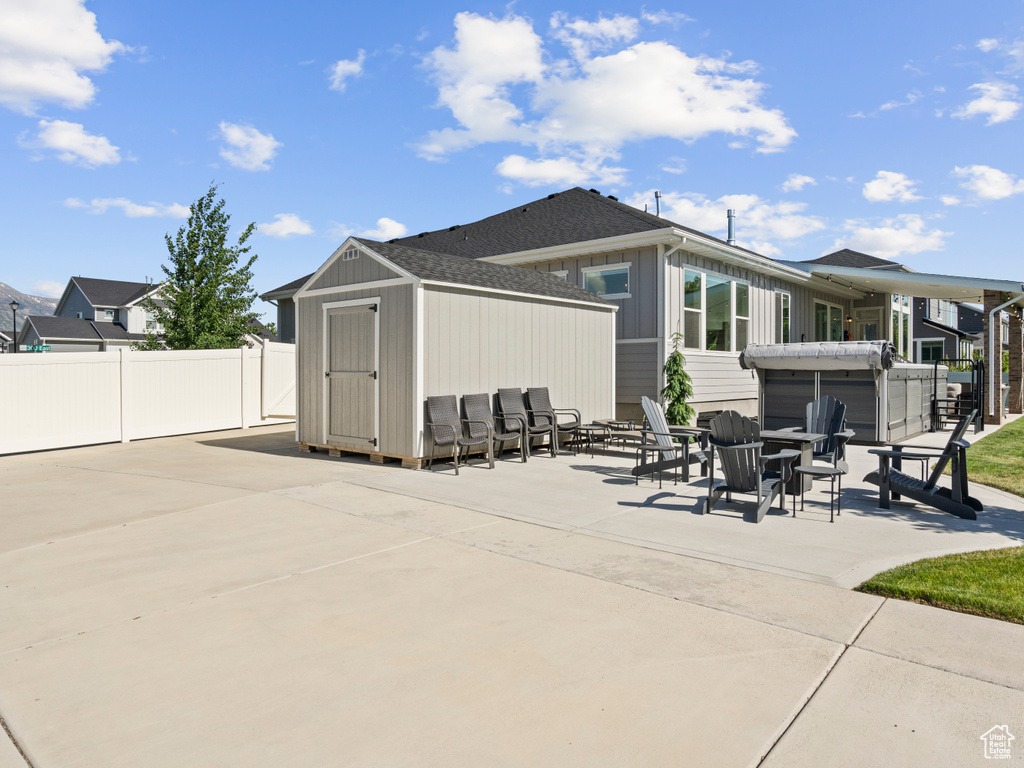 Back of property with a patio area and a shingled roof