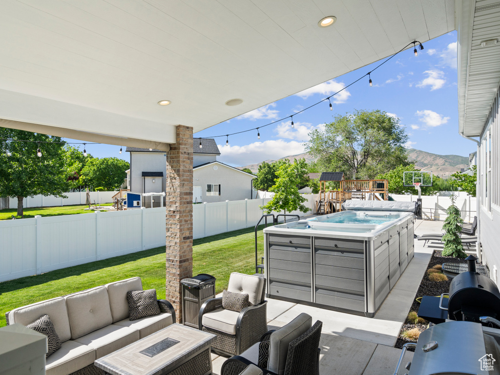 View of patio / terrace featuring outdoor lounge area, a hot tub, a mountain view, and grilling area
