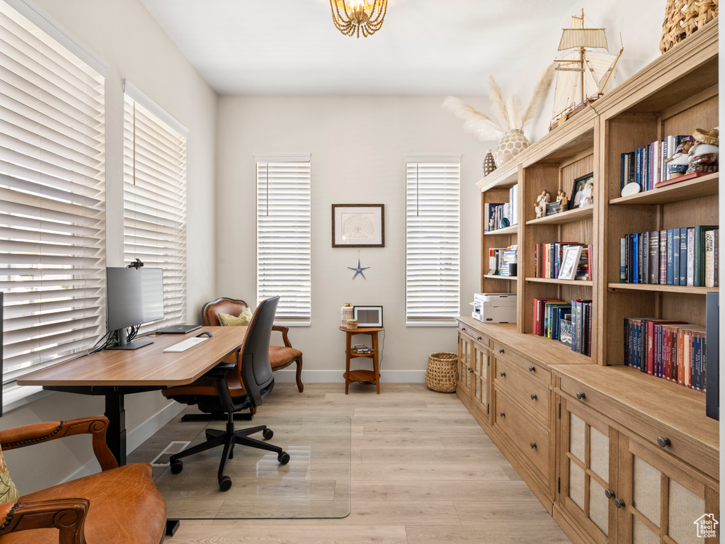 Office space with light wood-style flooring and baseboards