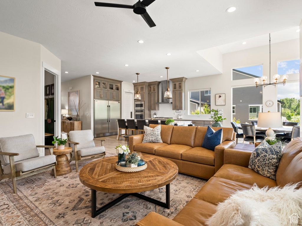 Living area featuring a chandelier, ceiling fan, recessed lighting, and light wood finished floors