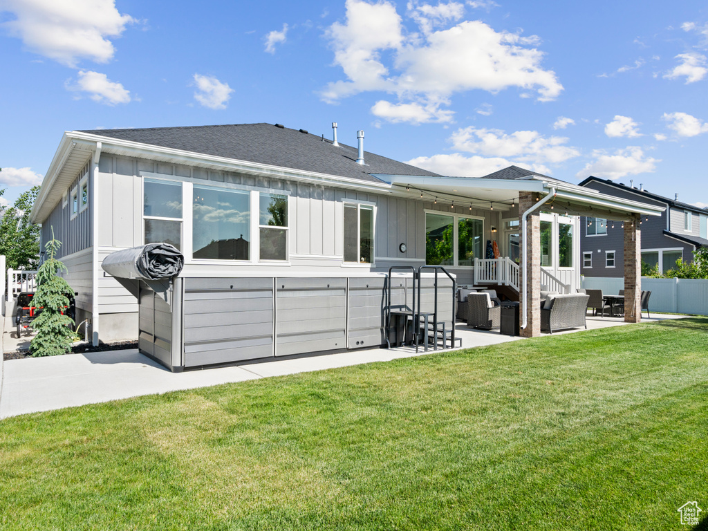 Rear view of property featuring board and batten siding, a patio, an outdoor living space, and a shingled roof