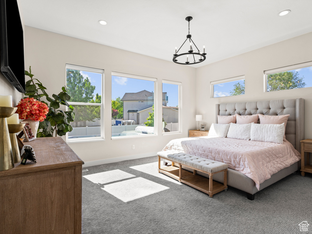 Carpeted bedroom featuring a chandelier, recessed lighting, and baseboards