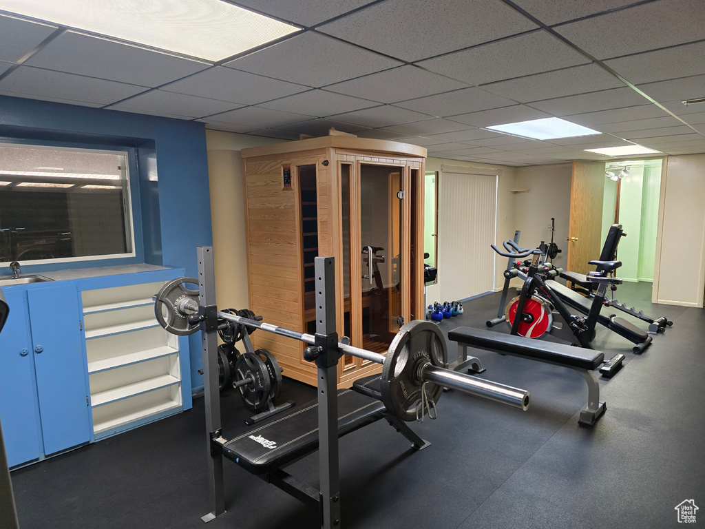 Workout area featuring a drop ceiling and a sink