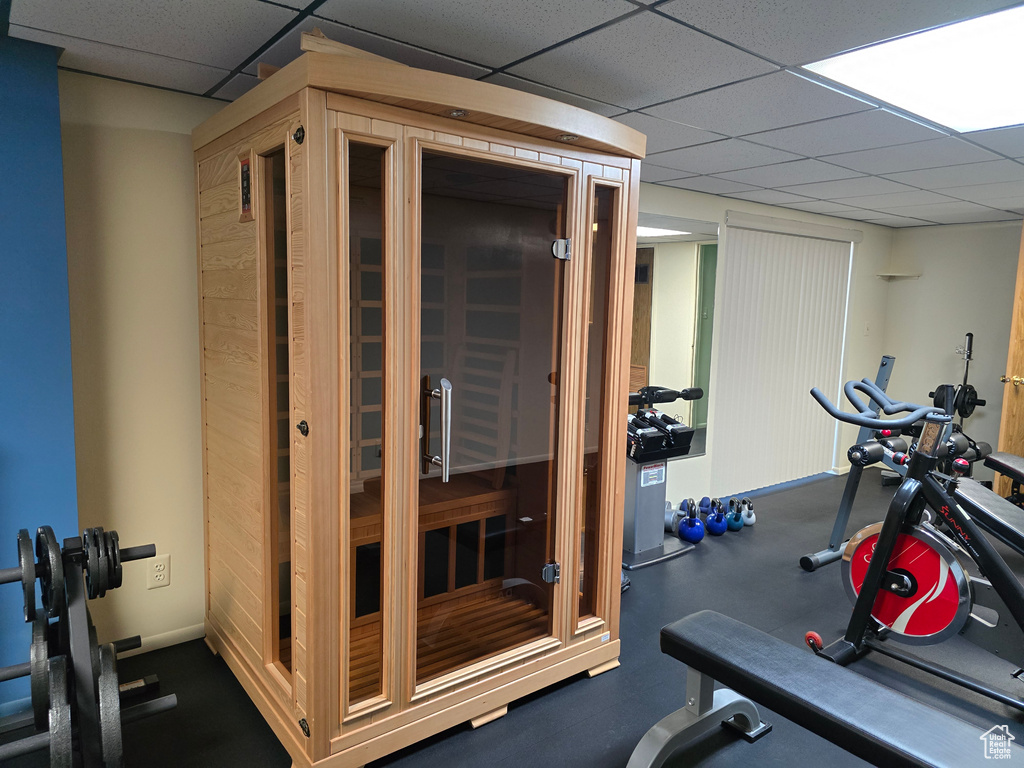Workout room featuring a drop ceiling and baseboards
