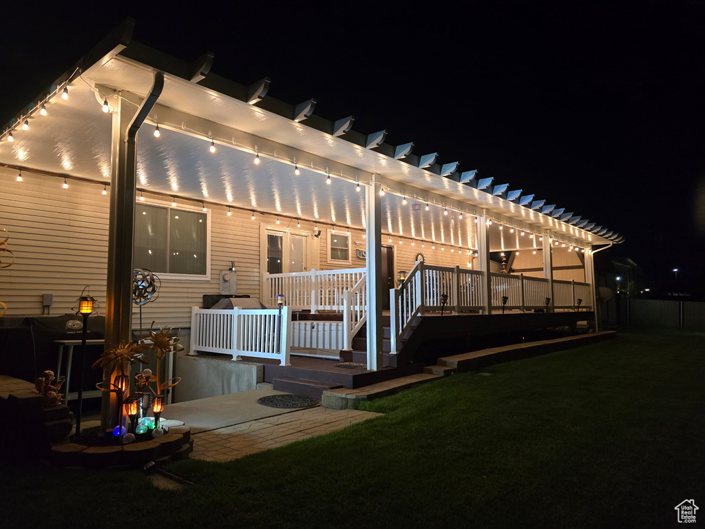 Back of house at twilight featuring a pergola