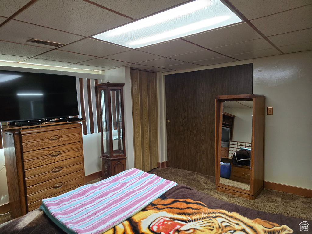 Bedroom with a paneled ceiling and carpet