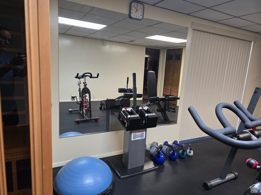 Exercise room featuring a drop ceiling and baseboards