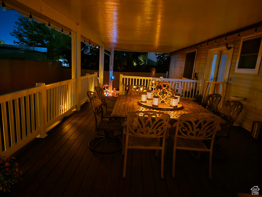 Deck at night featuring outdoor dining space
