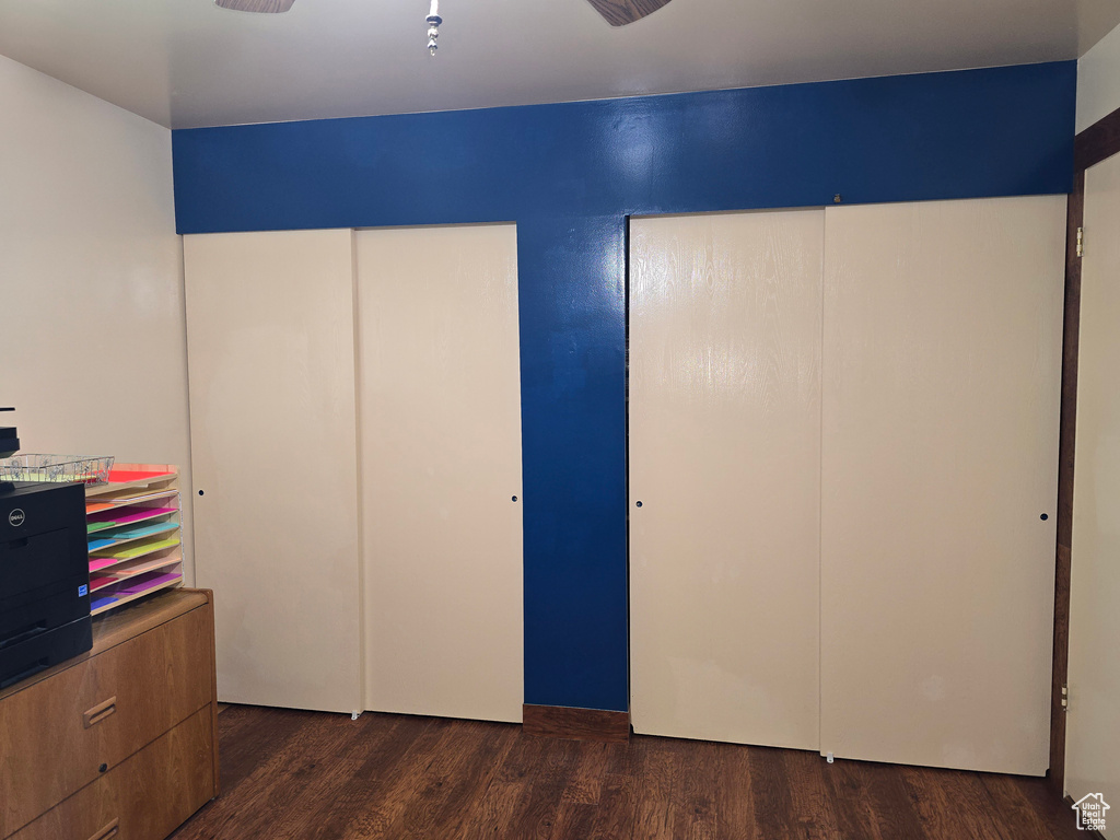 Bedroom with dark wood finished floors and two closets