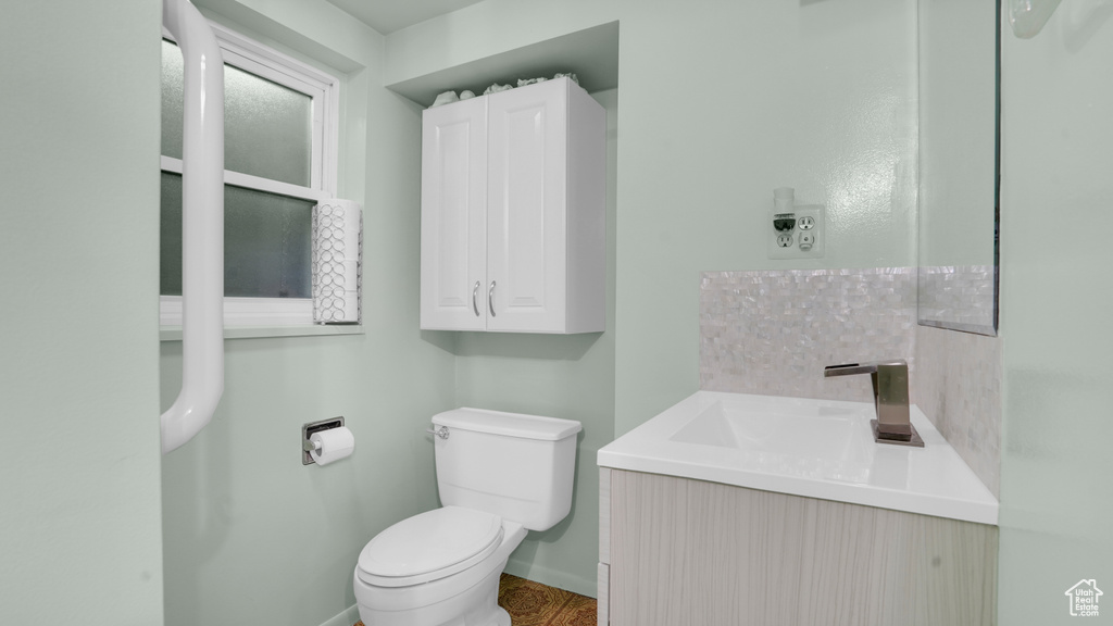 Bathroom with toilet, baseboards, and vanity