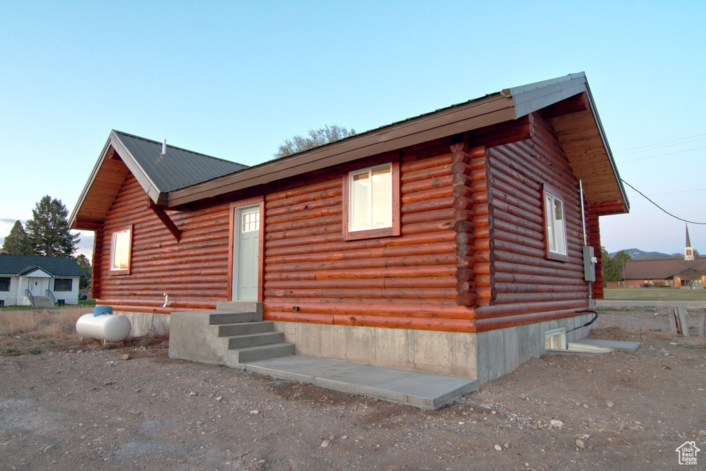 Log-style house featuring entry steps, log siding, and metal roof