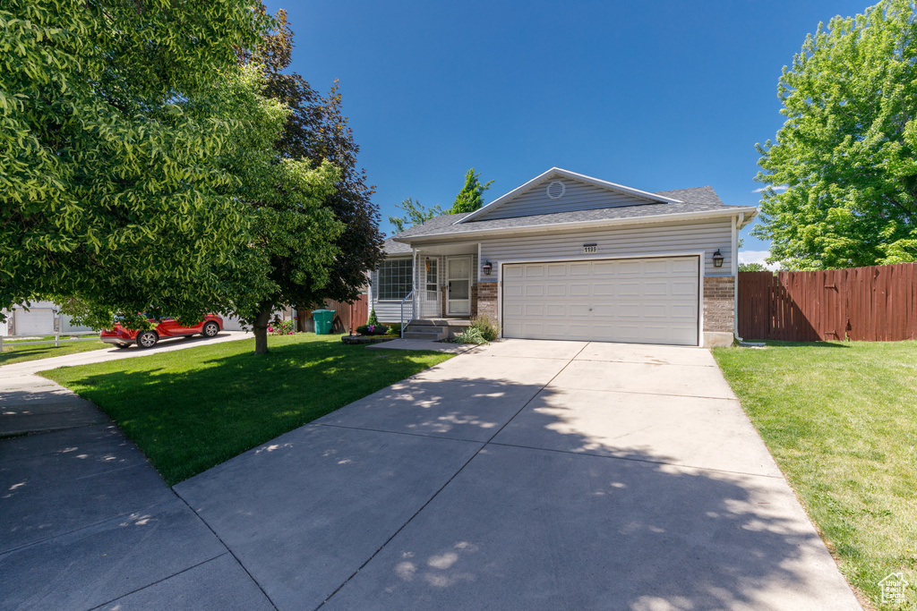Single story home with brick siding, driveway, and a garage