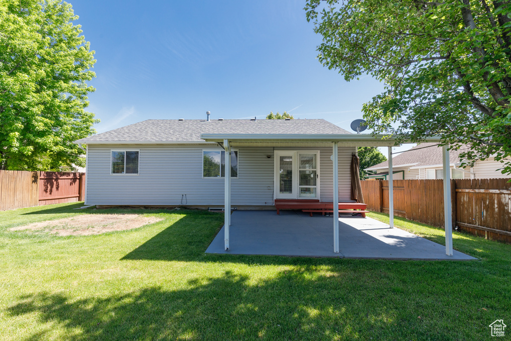 Rear view of house featuring a patio and roof with shingles