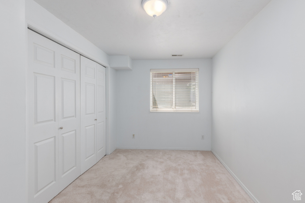 Unfurnished bedroom with carpet flooring, a closet, and baseboards