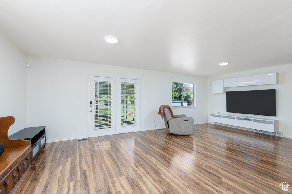 Living area with wood finished floors, baseboards, and recessed lighting