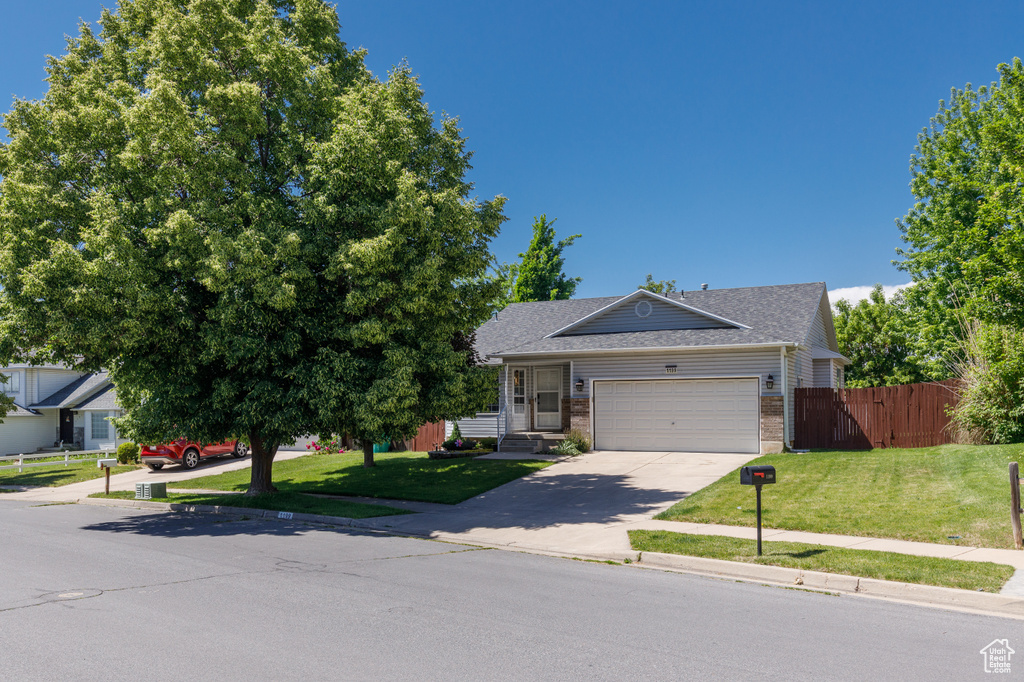 View of front of home featuring a garage, brick siding, driveway, and roof with shingles