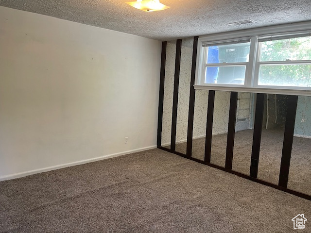 Spare room featuring carpet floors and a textured ceiling