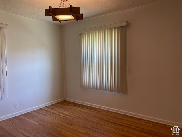 Unfurnished room featuring wood finished floors and baseboards