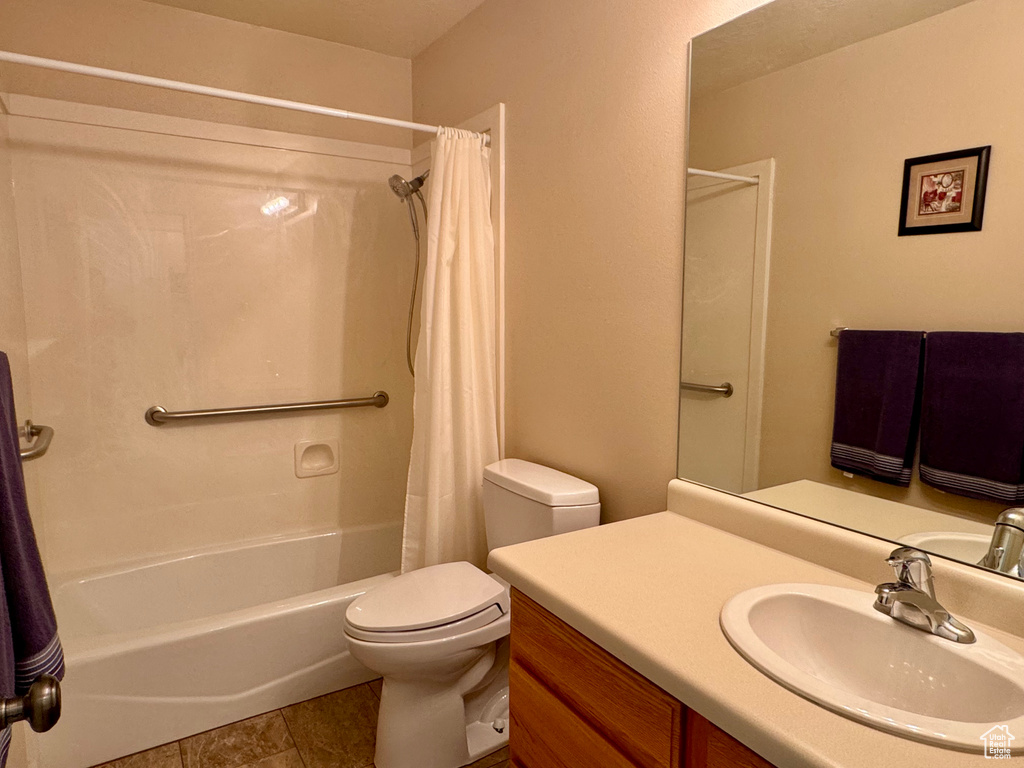 Full bathroom featuring shower / bathtub combination with curtain, vanity, toilet, and tile patterned floors