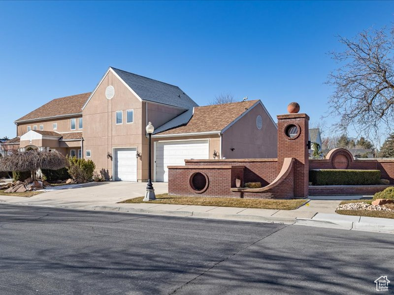 View of front of property with concrete driveway, stucco siding, and a garage