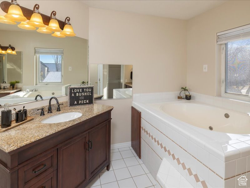Bathroom featuring vanity, a whirlpool tub, and tile patterned flooring
