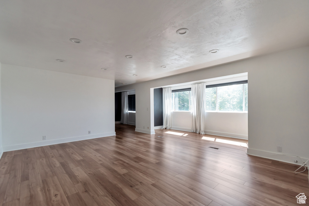 Spare room featuring wood finished floors and baseboards