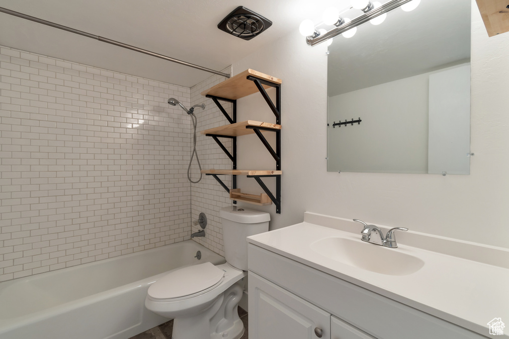 Bathroom with toilet, vanity, and bathing tub / shower combination