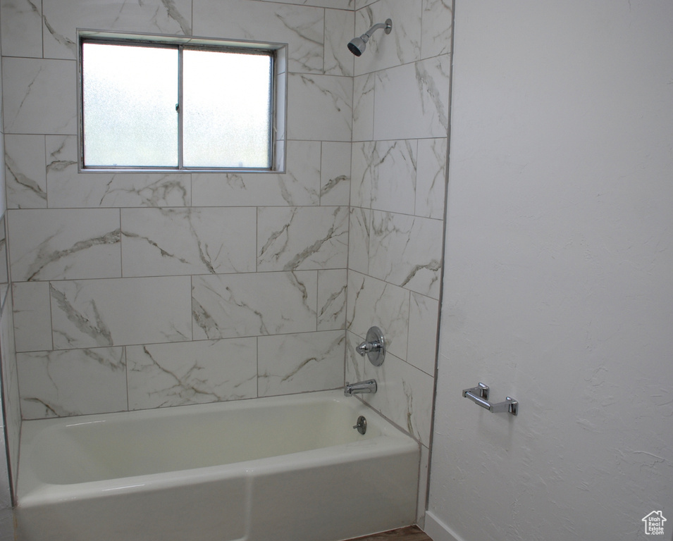 Bathroom with shower / tub combination and baseboards