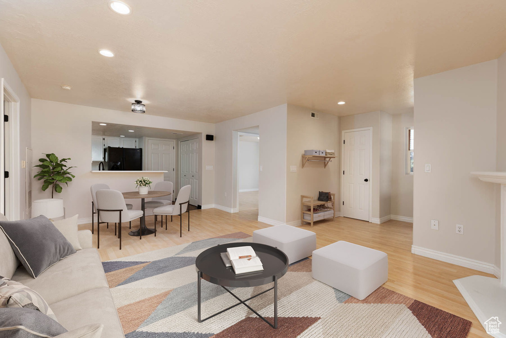 Living area with light wood finished floors, baseboards, and recessed lighting