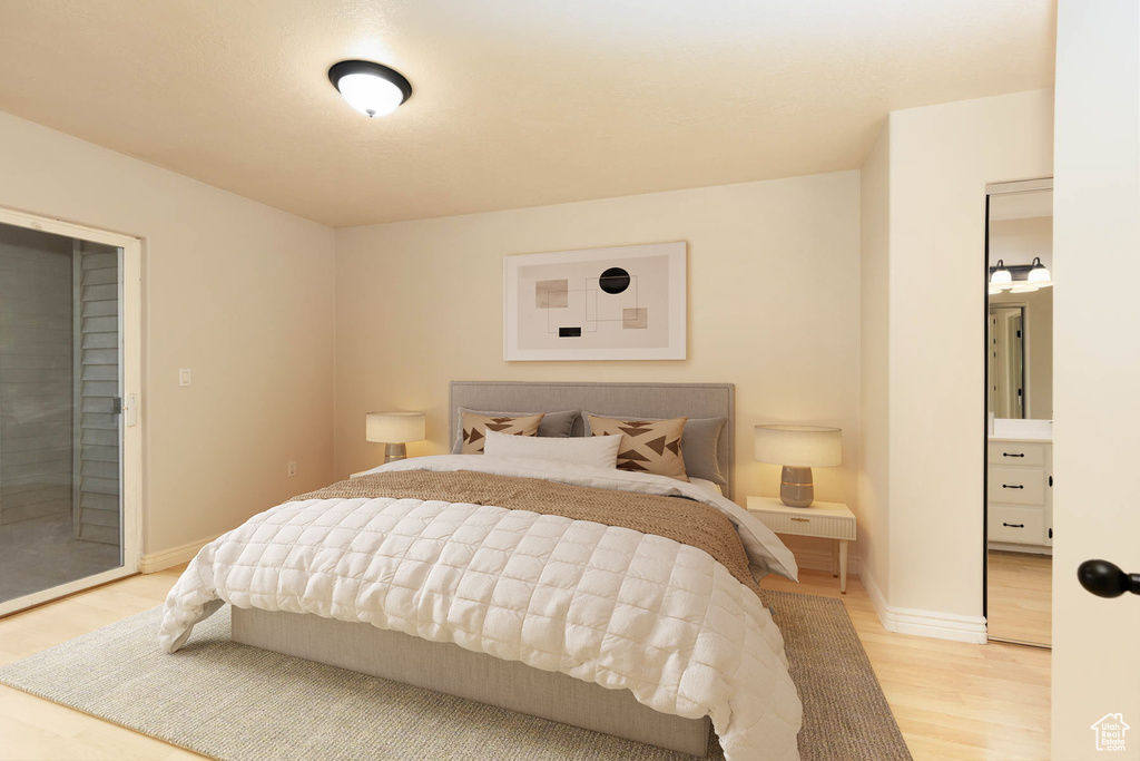 Bedroom featuring light wood-style floors, baseboards, and access to exterior