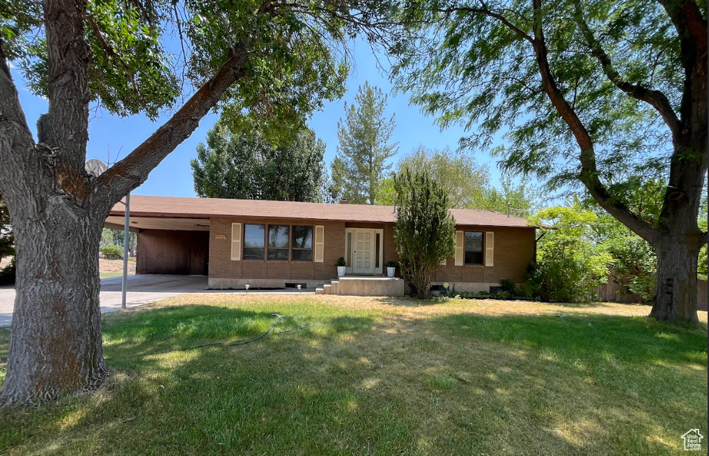 Single story home featuring an attached carport and a front lawn
