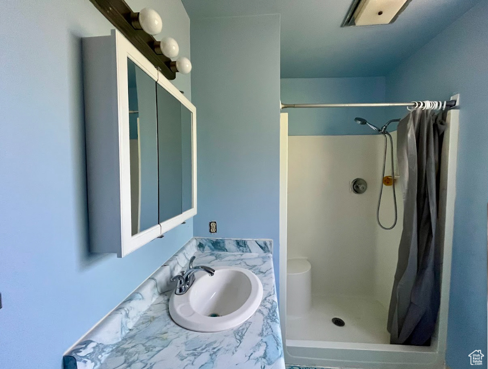 Bathroom featuring curtained shower and vanity