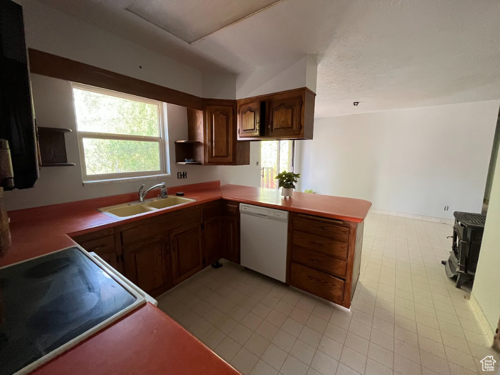 Kitchen with white dishwasher, electric range oven, and a peninsula