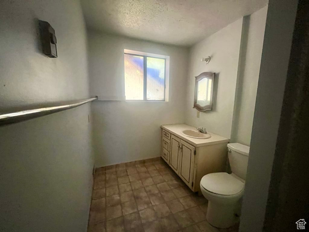 Half bathroom featuring vanity and a textured ceiling