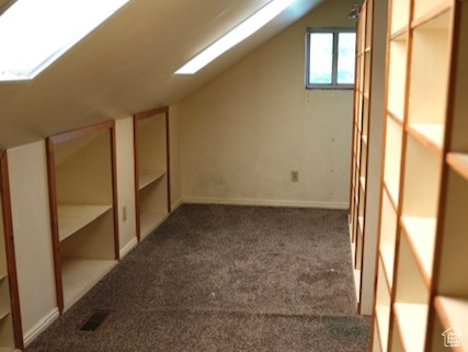 Additional living space with vaulted ceiling and carpet floors