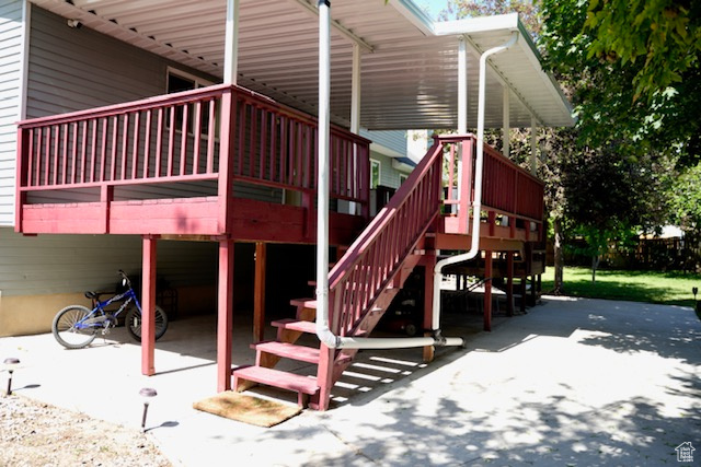 View of playground with a patio and a wooden deck