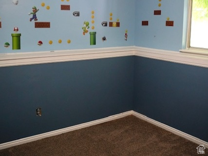 Carpeted empty room with a textured ceiling and baseboards