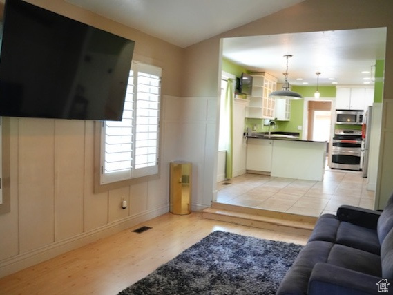 Living area featuring light wood-style floors and vaulted ceiling