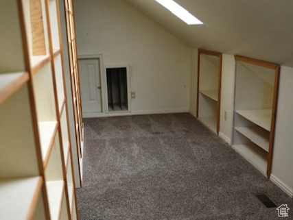 Additional living space with vaulted ceiling, carpet floors, and baseboards