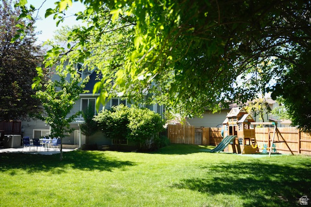 View of yard with a playground and a patio area