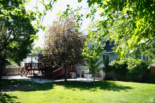 Rear view of house with stairway, a patio, and a wooden deck
