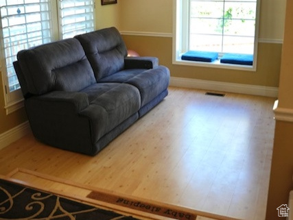 Living area with wood finished floors, baseboards, and lofted ceiling