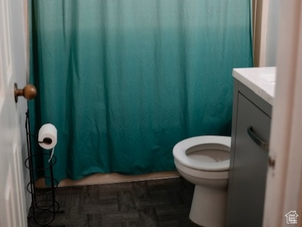 Bathroom featuring toilet, vanity, and a shower with shower curtain