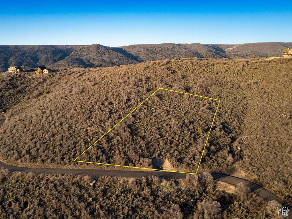 Aerial overview of property's location with a mountainous background and property parcel outlined