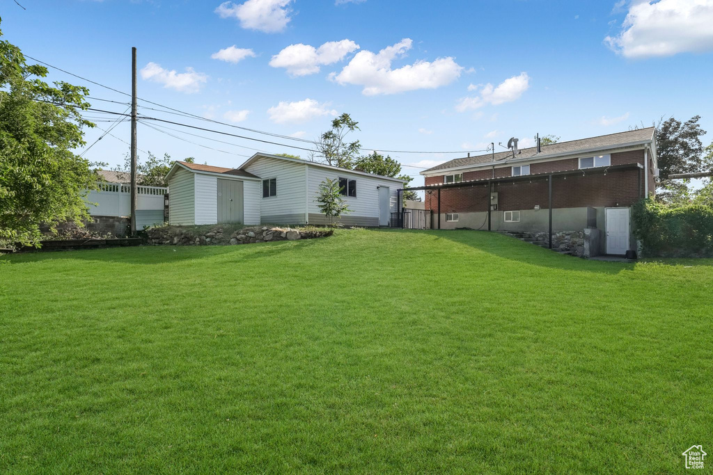 View of grassy yard with an outbuilding