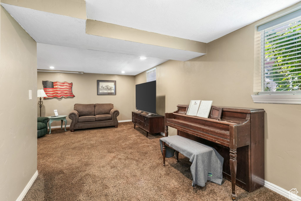 Carpeted living area with baseboards and recessed lighting